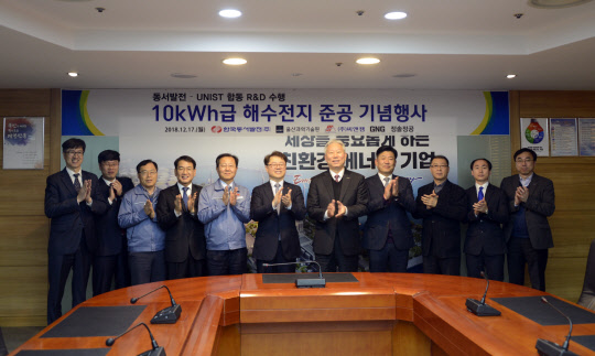 박일준 한국동서발전 사장(왼쪽 여섯번째), 정무영 울산과학기술원 총장(일곱번째) 등  양사 관계자들이 17일 울산화력본부에서 열린 '해수전지 ESS 설비' 준공 기념행사에서 사진을 찍고 있다. <동서발전 제공>